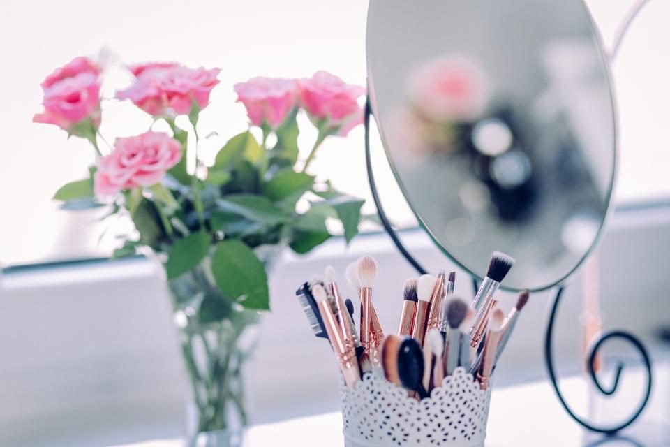 Brochas de maquillaje y flores